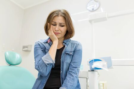 Adult woman sitting in chair of dentist in clinic and preparing for procedureの写真素材