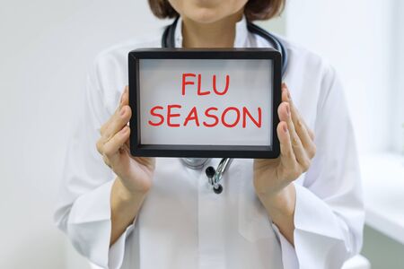 Flu season text in the hands of a female doctor.の写真素材