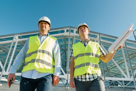 Male construction worker and engineer at the construction site. Building, development, teamwork and people concept.の写真素材
