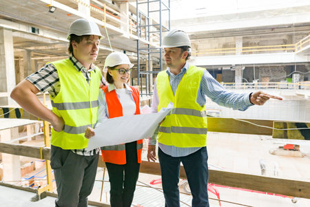 Group of engineers, builders, architects on the building site. Construction, development, teamwork...