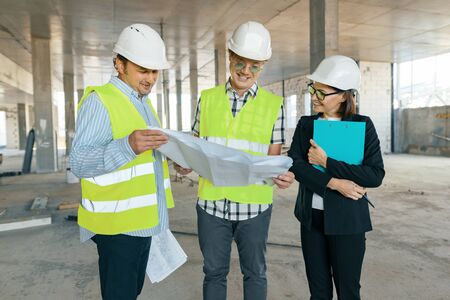 Group of engineers, builders, architects on the building site. Construction, development, teamwork and people concept.の写真素材