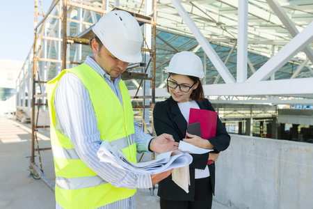Man engineer and woman architect at a construction site. Building, development, teamwork and people...