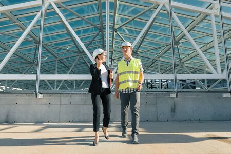 Woman engineer and man builder at construction site. Building, development, teamwork and people concept.の写真素材