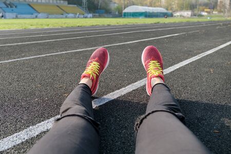 Stadium track background, treadmill female legs in sneakers, healthy lifestyle, running, spring season, sport outdoorの写真素材