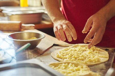 Close-up hands of male baker preparing traditional Georgian cuisine khachapuri. Process of cooking, culinary, recipeの写真素材