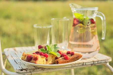 Hello summer, strawberry season. Cake with berries and jug with strawberry mint drink on vintage...