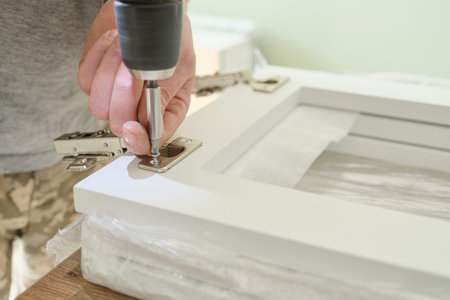 Furniture assembly. Closeup of workers hand with professional tools and furniture details