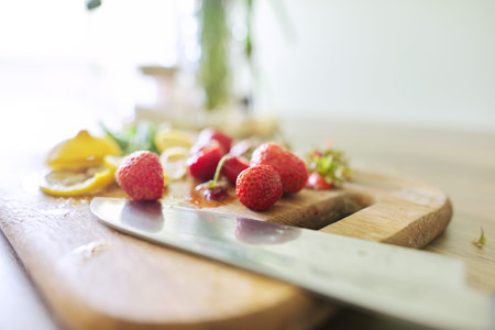 Making drink, close-up on cutting board strawberries mint lemon, knife.