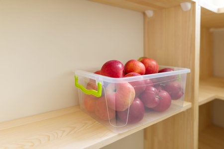 Food storage, wooden shelves in the pantry with apple containers.