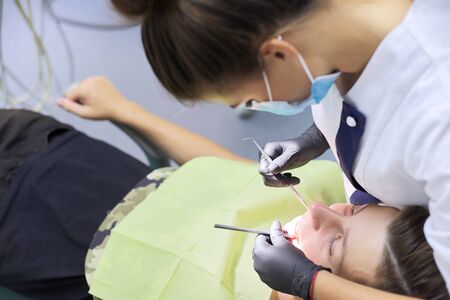 Dental treatment at the dental clinic, female doctor treating patient.の写真素材