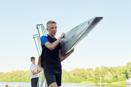 Active healthy lifestyle teens. Boys 15, 16 years old paddling sport kayak. Teenagers carrying two-seater sports boatの写真素材