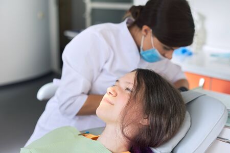Young girl treating teeth, female teenager sitting in dentists chair. Dentistry, healthy teeth, medicine and healthcare conceptの写真素材