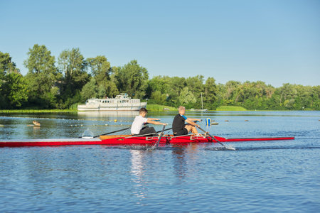 Active healthy lifestyle teens. Boys 15, 16 years old paddling sport kayak. Teenagers in double boat...