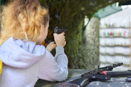 Close-up of teenage girl shooting training pistol at shooting range.の写真素材