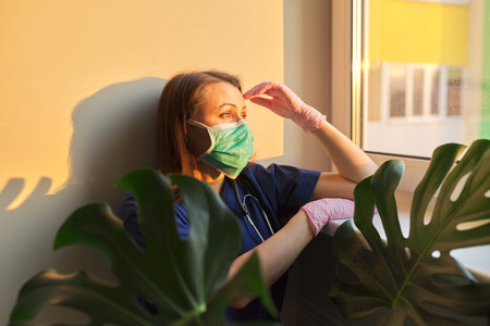 Portrait of doctor woman using medical face mask in prevention against virus infection, blue...