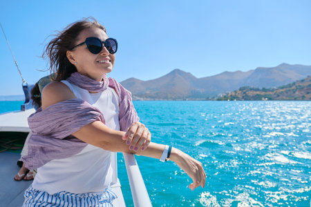Beautiful mature woman enjoys summer sea trip, female on side of small pleasure boat. Mediterranean...