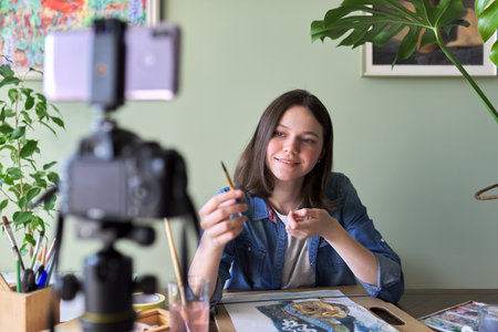 Artist girl painting with watercolors and making videos for her channel blog. Girl showing what...