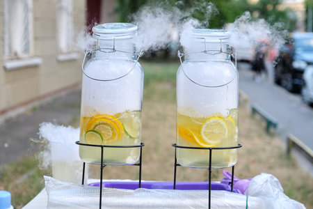 Large cans of natural lemonade with liquid nitrogen, dry ice. Street drinks with you, plastic cups