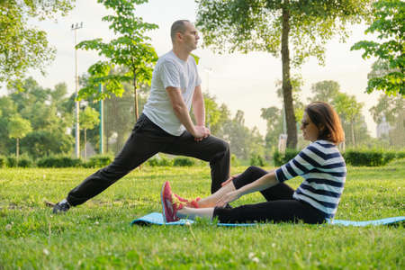 Mature couple doing sports exercises in park. Active healthy lifestyle, sport, fitness in middle-aged peopleの写真素材