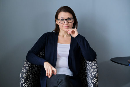 Portrait of middle aged woman professional psychologist in office, specialist looking at camera....