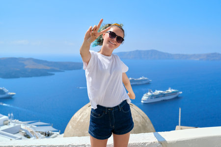 Young beautiful teenager girl tourist posing smiling, background summer sunny scenic sea landscape...