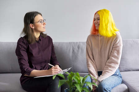 Woman psychologist working with teen girl. Visit and counseling of professional mental and social therapist. Psychology, teenager, problem, trauma, mental health of adolescents conceptの写真素材