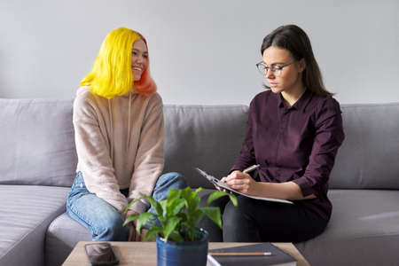 Woman psychologist working with teen girl. Visit and counseling of professional mental and social therapist. Psychology, teenager, problem, trauma, mental health of adolescents conceptの写真素材
