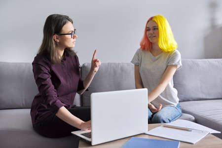 Female teacher teaches individually college student, teenager and tutor working in office on couch. Education, help, teaching, school conceptの写真素材