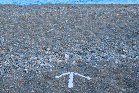 Arrow forward concept, arrow lined with white pebbles on black sea pebbles, copy spaceの写真素材