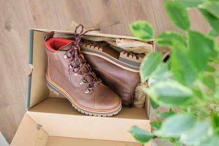 New womens leather brown waterproof hiking winter autumn boots in a box, trendy footwear for winter. Unpacking boots, shopping online from home, shoe fashion storeの写真素材