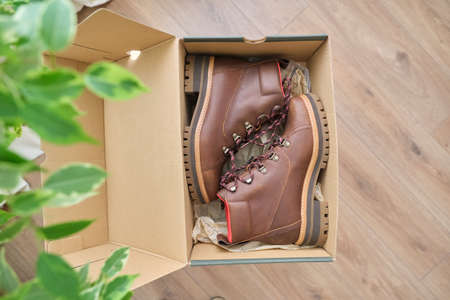 New womens leather brown waterproof hiking winter autumn boots in a box, trendy footwear for winter. Unpacking boots, shopping online from home, shoe fashion storeの写真素材