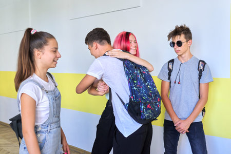 Meeting of teenage students at school, greeting and hugging. Friendship, school, college, teenagers...