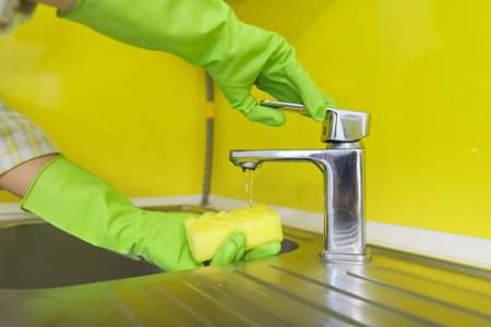 Close-up of cleaning kitchen, womans hands in rubber gloves with sponge detergent washing the sinkの写真素材
