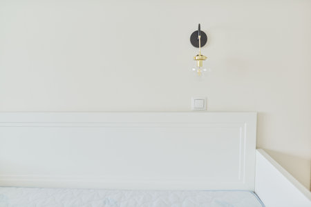 Bedside wall lamp above the bed, round glass ball lamp with LED light bulb. Lighting in the childrens bedroomの写真素材