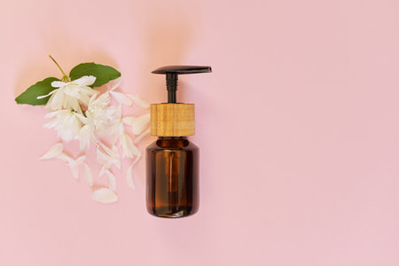 Cosmetology, treatment, beauty, natural organic cosmetic product in bottle with jasmine flowers on pink background, top viewの写真素材