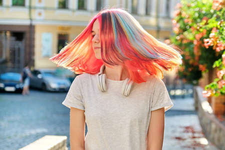 Hairstyles, hairs, fashion, trends, coloring. Close-up of fluttering colored dyed hair of young woman on sunny city streetの写真素材