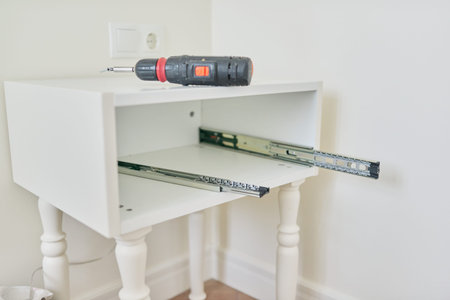 Furniture details close-up, installation of drawers in the bedside table, nobody. Renovation, new...