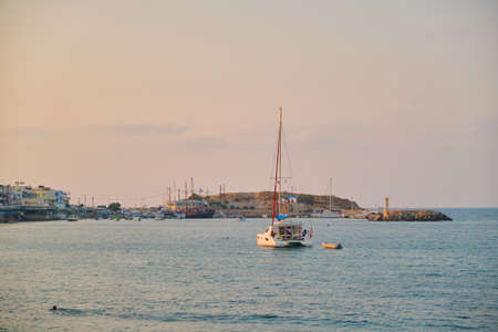 Greece Crete Hersonissos Heraklion, 11-09-2019. Greek seaside town lifestyle, fishing and tourist boats at sea, evening, sunsetのeditorial素材