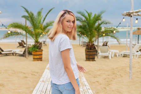 Beautiful model blonde teenager on the evening beachの写真素材