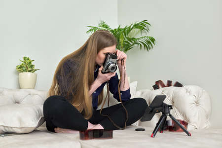 Young woman with vintage camera, photographic films, blogger recording streamの写真素材