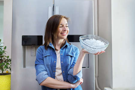 Woman with bowl with ice cubes for cooling foodの写真素材