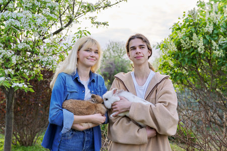Teenagers with rabbits in their hands, pets a couple of decorative rabbits