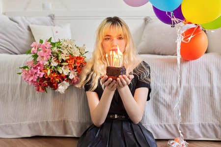 Birthday of female teenager, girl with cake and festive candlesの写真素材