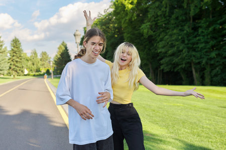 Laughing couple of teenagers looking at smartphone screen and recording videos