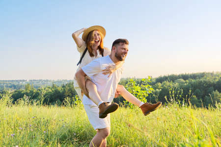 Happy laughing adult couple having fun outdoors, nature sky backgroundの写真素材