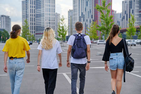 Group of teenagers walking together, back view, urban style, modern city backgroundの素材 [FY310173149695]