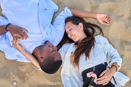 Top view of a young multiracial couple in love on the sandの写真素材