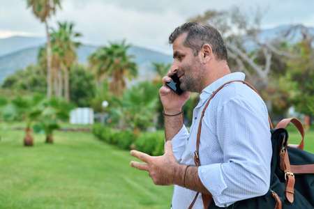 Mature business man talking on the phone outdoorsの写真素材