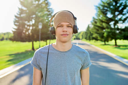 Portrait of teenage hipster in knitted hat with headphones looking in cameraの写真素材