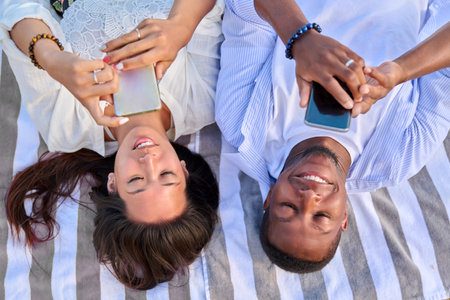 Top view smiling young couple looking at smartphone screensの写真素材